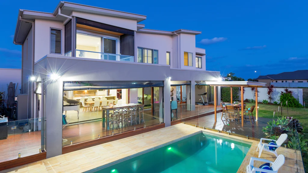 Modern two-story home with smooth stucco exterior finish and pool patio at dusk – Toms River Stucco