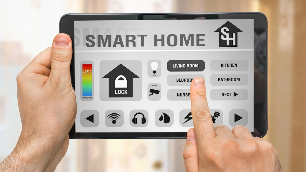 Hands holding a tablet with smart home control panel showing room and security settings – Toms River Stucco