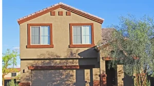 Two-story home with tan stucco exterior and terracotta trim and roof tiles – Toms River Stucco